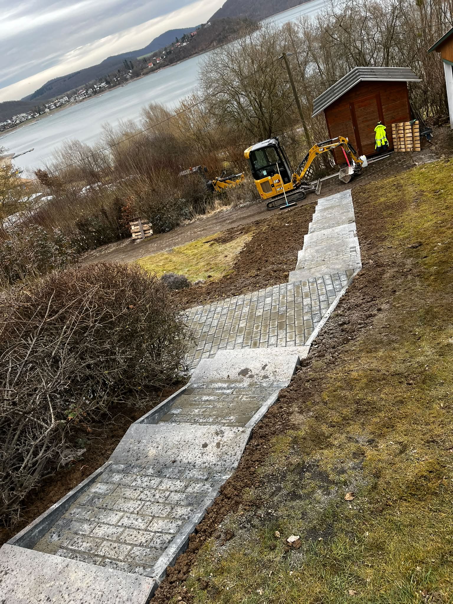Neu gepflasterter Treppenweg mit Stufen am Hang mit Seeblick